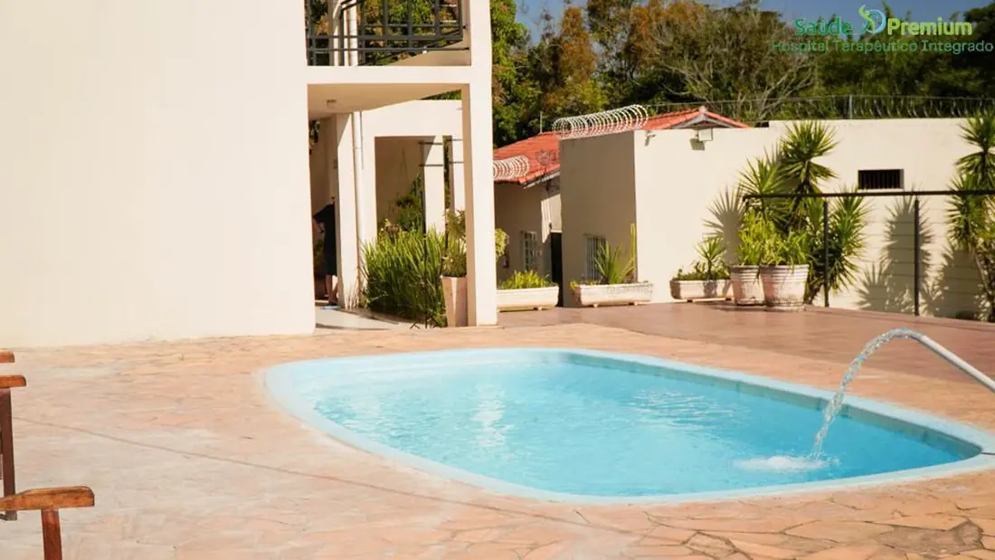 Piscina e área de jardim na unidade Capela do Alto