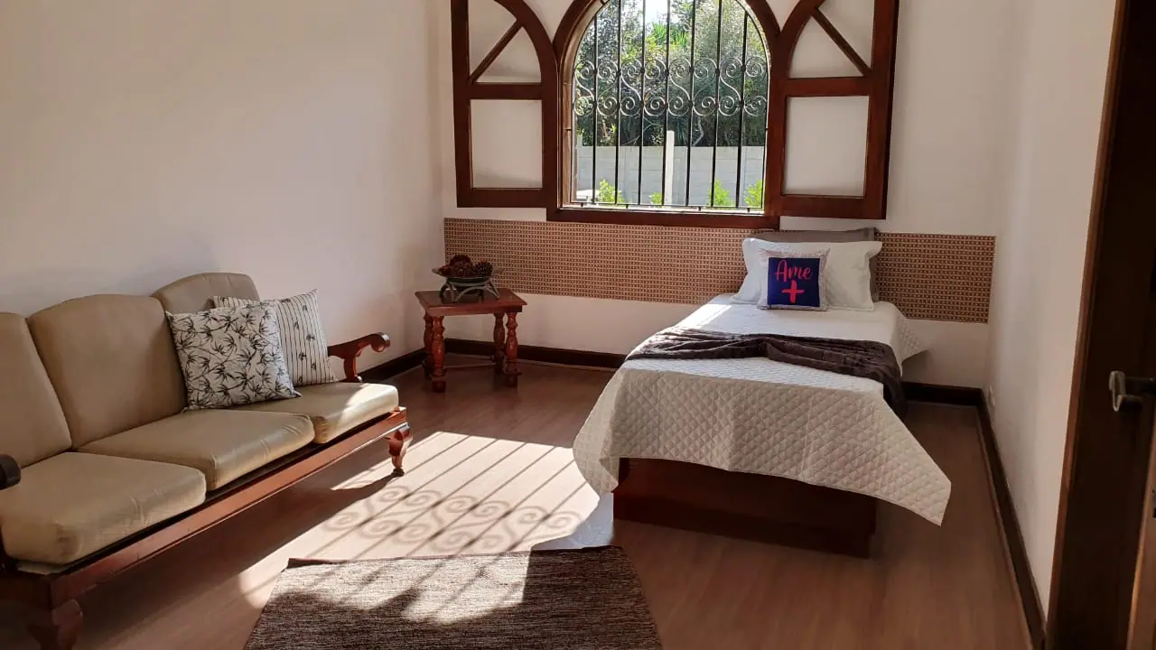 Quarto com poltrona e sofá na unidade Granja Viana