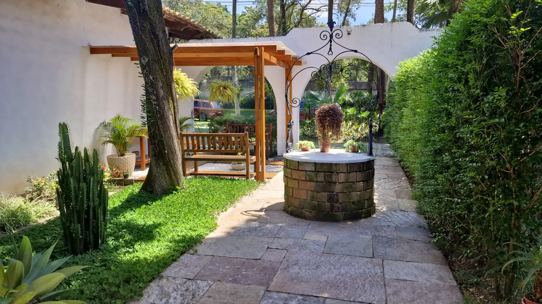 Jardim com pergolado e caminho de pedra na unidade Granja Viana