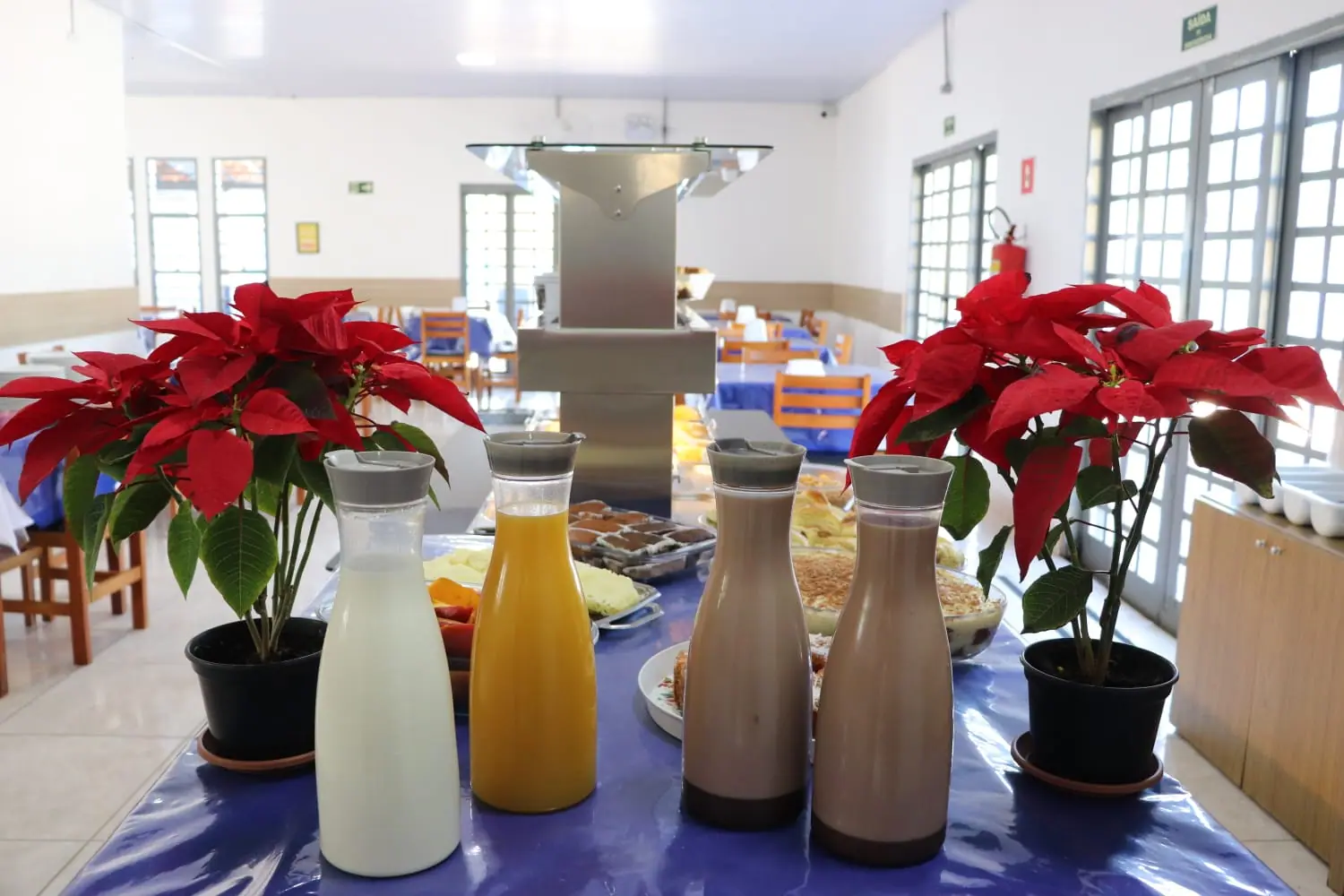 Refeitório com mesas postas e café da manhã na unidade São Roque